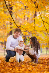 Naklejka na ściany i meble happy young family spending time outdoor in the autumn park