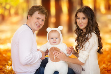 happy young family spending time outdoor in the autumn park