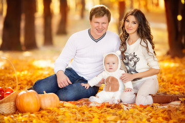 happy young family spending time outdoor in the autumn park