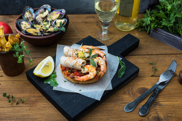 Italian food. Bruschetta with squid and prawns, tomatoes, parsley.