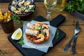 Italian food. Bruschetta with squid and prawns, tomatoes, parsley.