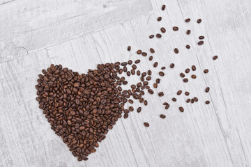 Heart made of coffee beans on a wooden background