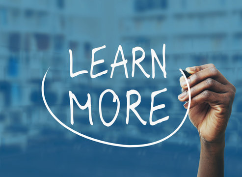 Male hand writing text learn more on screen. Business training concept.