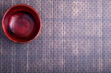 Surface of the table with a brown wooden bowl