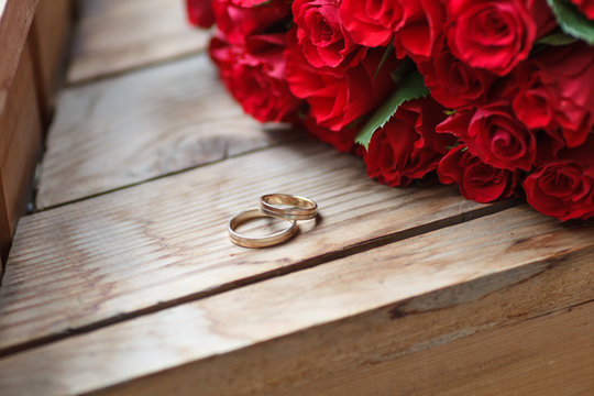 Wedding rings and red roses