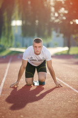 Detailed view of a sprinter getting ready to start. Selective focus.