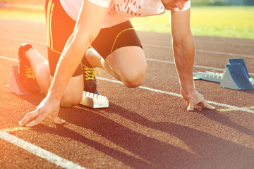 Athletic man starting jogging in sun rays