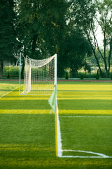 Fototapeta premium right side view of standard goal and net in football pitch or soccer field, sport equipment in the stadium
