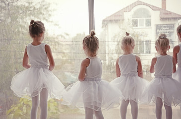 Cute girls standing near window in ballet class