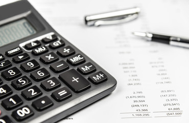 Calculator and pen on financial statement paper. Business accounting concept.