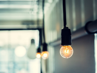 Row of illuminated retro light bulb decoration. Photo with vintage style tone.