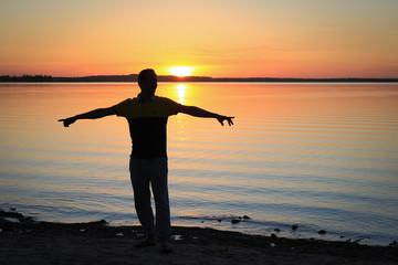 Silhouette of Man with Outstretched Arms in the Sunset
