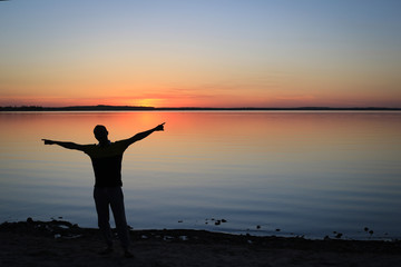 Silhouette of Man with Outstretched Arms in the Sunset
