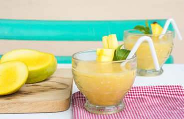 Fototapeta premium Mango juice in glass on table cloth and mango fruit,