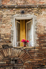 Fototapeta na wymiar red flowers at a window in Tuscany