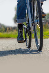 Fototapeta premium Eine Frau fährt mit dem Fahrrad auf einer Asphaltstrasse entlang