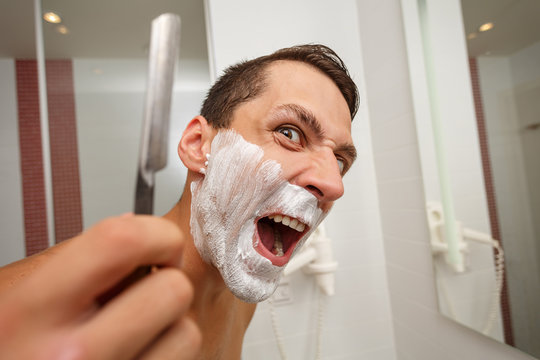Man is holding a straight razor.