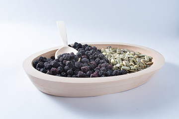 Fototapeta na wymiar Aronia and Pumkin seeds in wooden bowl