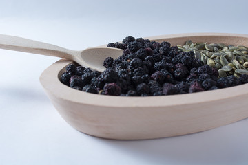 Aronia and Pumkin seeds in wooden bowl