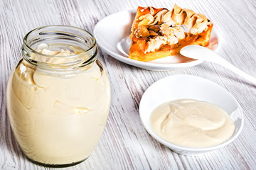 Sour Cream in glass jar with piece of apricot tart
