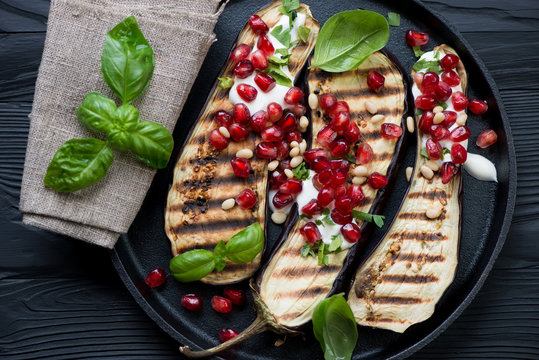 Above view of grilled aubergines with pomegranate and sour cream