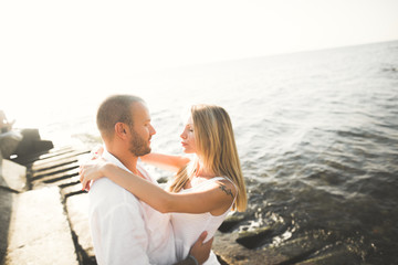 happy just married young wedding couple celebrating and have fun at beautiful beach sunset