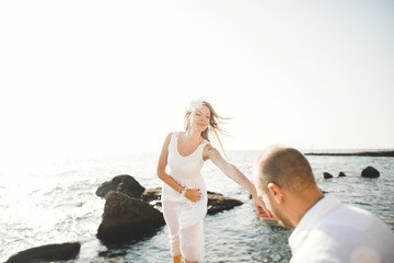 Happy romantic fashion couple in love have fun on beautiful sea at summer day