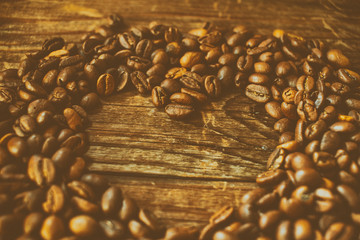 Coffee beans arranged in a heart shape. The effect of film grain.