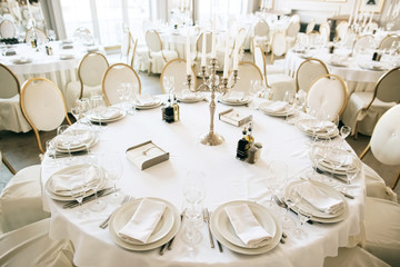 Elegant table arrangement and catering at wedding reception. White style