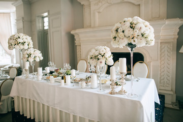 Table decor with white flowers and candles for an event party or wedding reception