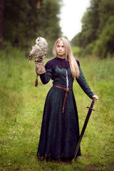 Fototapeta premium girl with a sword holding an owl