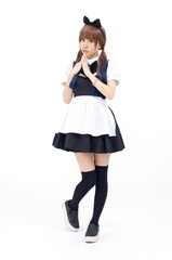 女性モデルが、メイド服を着てポーズをしています。背景は白です。