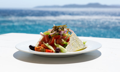 Griechischer Salat vor glitzerndem Meer