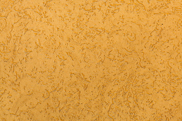 Yellow ochre painted stucco wall. Background texture