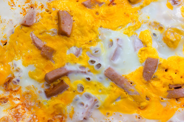 background, yellow scrambled eggs with pieces of sausage, top vi
