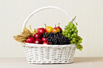 White basket with grapes, apples and pears.