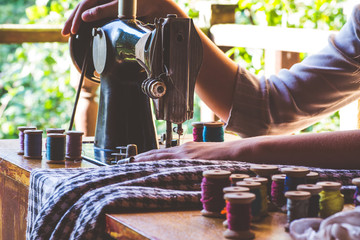 Young girl sews on the old sewing machine