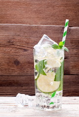 cocktail with lime and ice on an old table
