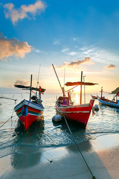 Sunset on the beach with colourful fishing boats
