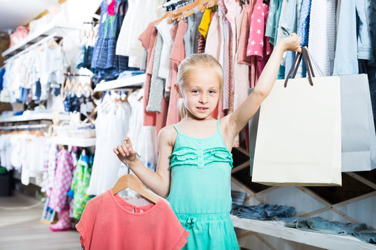 happy girl in children clothes shop