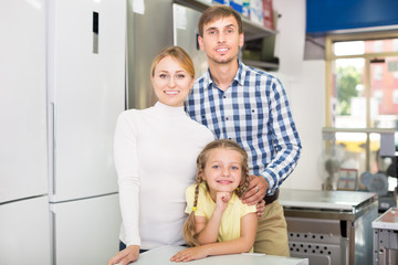 Fototapeta na wymiar Parents with daughter in home appliance store