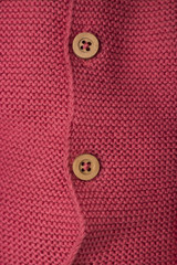 A fragment of pink marsala knitted baby cardigan with buttons