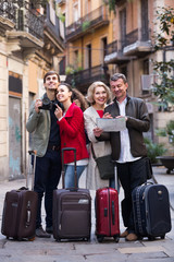 Portrait of tourists with map and baggage seeing the sights in E