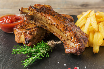 baked pork ribs with french fries and red sauce - obrazy, fototapety, plakaty