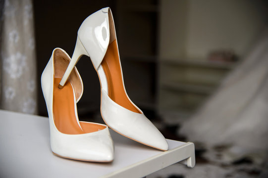 White lacquer wedding shoes bride. Women's elegant shoes. Dressing the bride and wedding accessories.