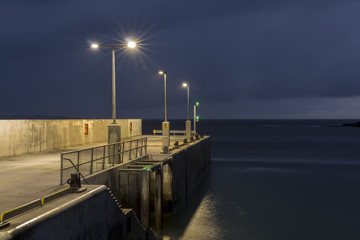 Doolin pier at dusk. The lights on the pier are on as night falls in Co. Clare, Ireland.