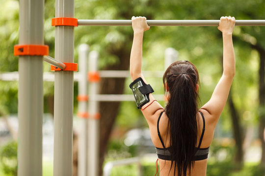 Fitness Woman Working Out Doing Pull Ups In Park