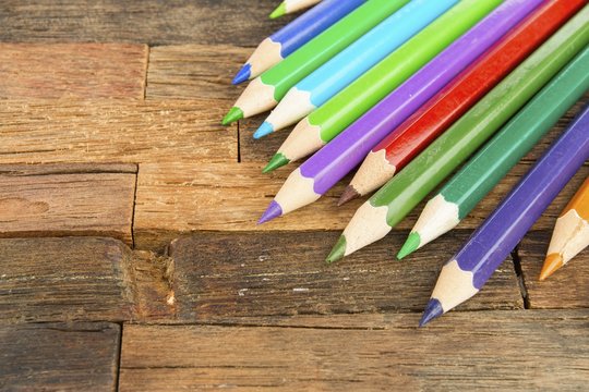 Colored pencils on wooden background. Stock image macro.