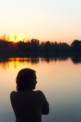 Silhouette of a woman in the river at sunset.