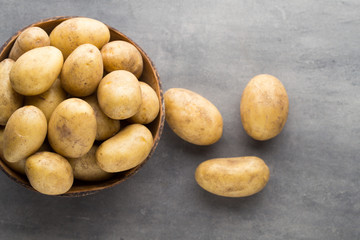 New potato on the bowl, gray background.